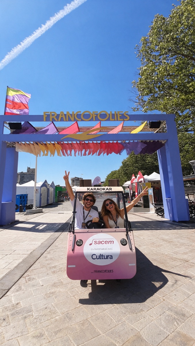 Deux passagers à bord d’un OuiCycle sous l’arche d’un festival